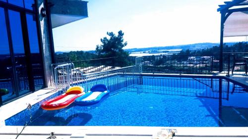 a swimming pool with two inflatables in it at Villa15 Lodge, Five-Star Stay 5BD 5-5BA Beach Access Villa with Pool , Gym, Sauna, Alfresco Dining & Garden in Manavgat