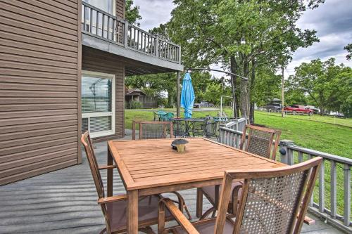 a wooden table and chairs on a deck at Lakefront Home with Private Beach Access! in Eufaula