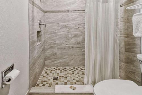 uma casa de banho com um chuveiro, um WC e um lavatório. em Rodeway Inn & Suites em Haines City