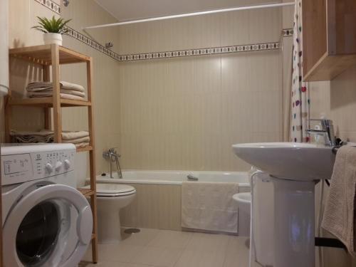 uma casa de banho com uma máquina de lavar roupa e um lavatório em Apartamento Playa de Boiro em Boiro