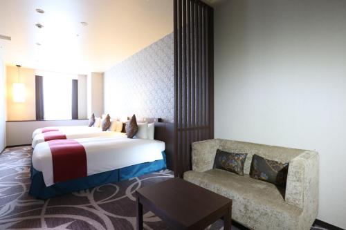 a hotel room with a bed and a chair at Quintessa Hotel Osaka Bay in Osaka