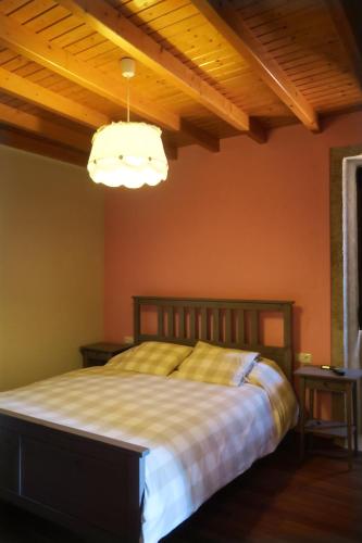 a bedroom with a bed and a wooden ceiling at Casa do Rei in Boiro