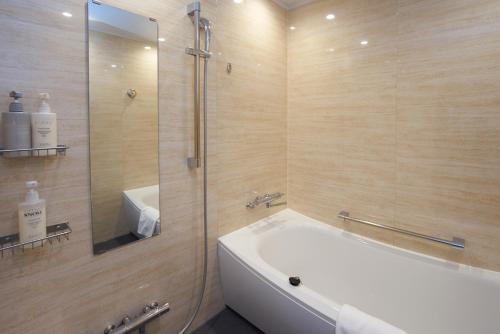 a bathroom with a tub and a shower and a sink at Quintessa Hotel Osaka Bay in Osaka