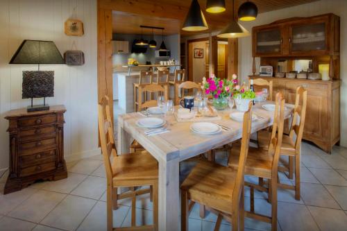 une salle à manger avec une table et des chaises en bois dans l'établissement Chalet L'Otavalo - OVO Network, à Manigod