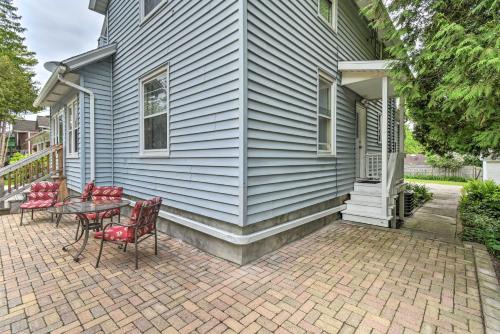a house with red chairs and a table on a brick patio at Cozy Unit with Patio Walk to Dining, Lake Elkhart! in Elkhart Lake