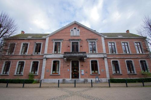 a large red brick building on a street at Hotel des Comtes Durbuy in Durbuy