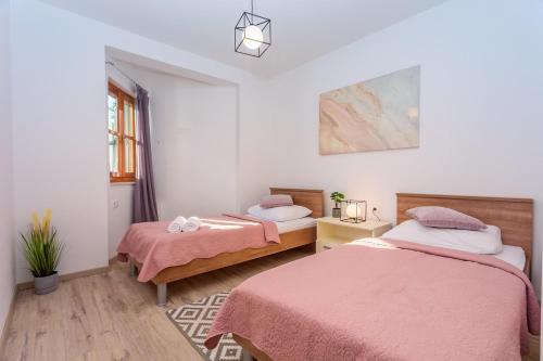 a bedroom with two beds and a window at VILLA SKURA private heated pool 32m2, summer kitchen, 4 bedrooms, garden in Duće