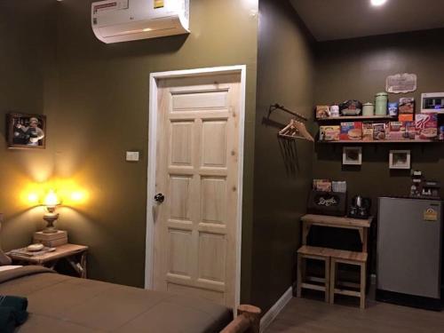 a bedroom with a bed and a white door at The Green Land Farm in Si Khio