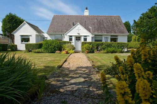a white house with a roof and a yard at CAE GRUGOG COTTAGE-3 Bed-Sleeps 6-Ground Floor Bathroom in Trearddur