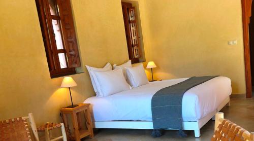 a bedroom with a large white bed with white pillows at Domaine Casa Cecilia in Marrakech
