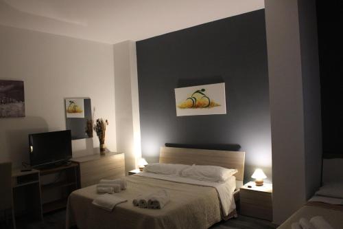 - une chambre avec un lit et une télévision dans l'établissement Triathlon B&B, à Lecce