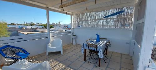 eine Terrasse mit einem Tisch und Stühlen auf dem Balkon in der Unterkunft Santorini house in San Pietro in Bevagna