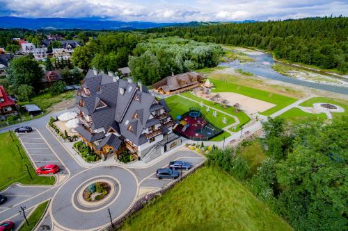an aerial view of a large house with a river at Hotel Burkaty in Białka Tatrzanska