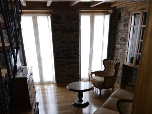 sala de estar con mesa, sillas y ventanas en Casa Lolola, en Sada