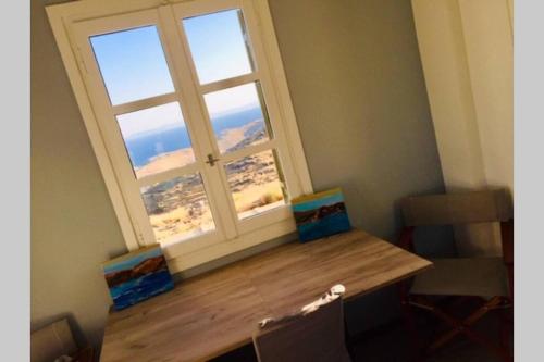 a window in a room with a wooden table in front of it at starryhouse in Fotimárion