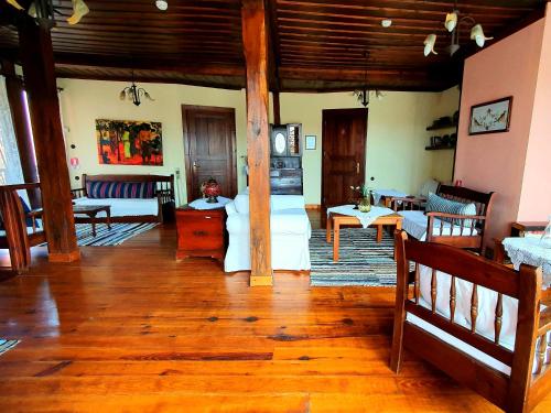 a living room with wooden floors and a living room with couches at Varosi Guesthouse in Edessa