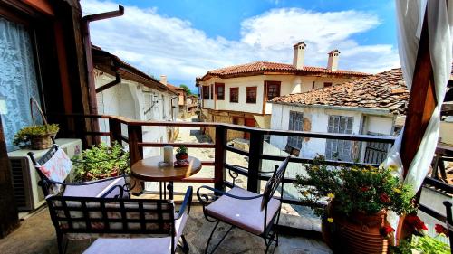a balcony with chairs and a table and some buildings at Varosi Guesthouse in Edessa
