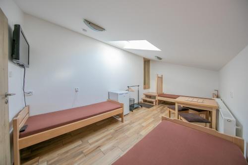 an empty room with benches and a tv in it at Na Rybníčku Bohutín in Bohutín