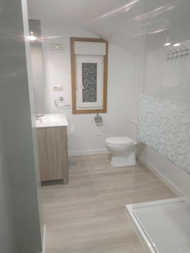 a white bathroom with a toilet and a sink at Nores Buenavista 2 in Vilaboa