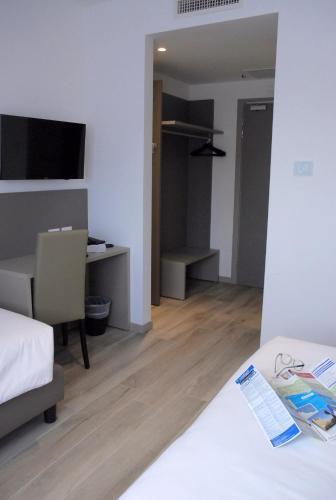 a bedroom with a bed and a desk with a computer at Hotel Sonia in Trieste