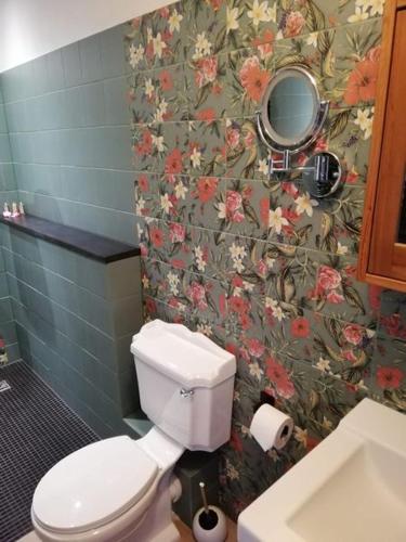 a bathroom with a toilet and a flower wallpaper at Traumparadies in Bad Sulza