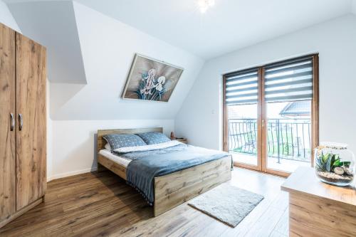 a bedroom with a bed and a large window at Apartament Parzenica in Poronin