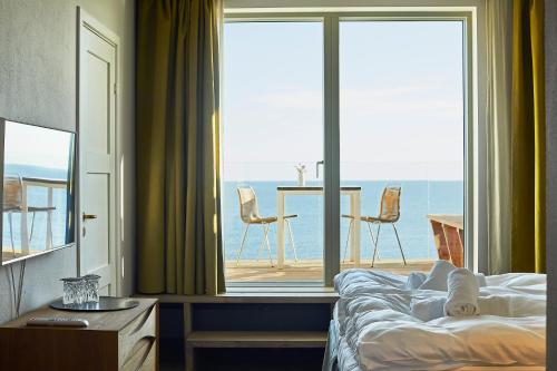 a bedroom with a large window with a view of the ocean at Nordlandet in Allinge