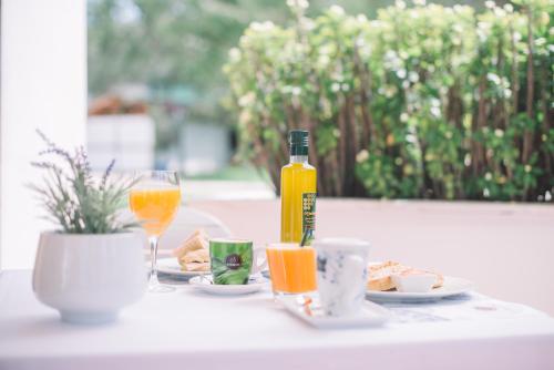 una mesa con una botella y vasos de zumo de naranja en Cortijo Chico Málaga Airport, en Alhaurín de la Torre