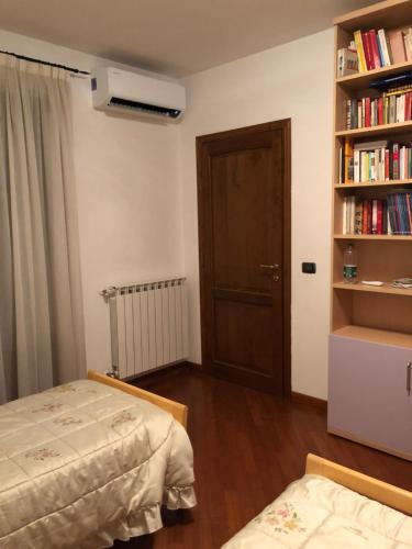 a bedroom with two beds and a book shelf with books at Mia in Marina di Massa