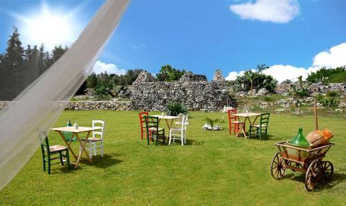 a group of tables and chairs in a field at Masseria Petra in Martano