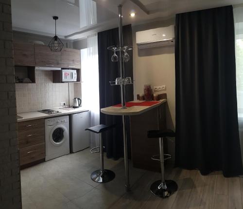 una pequeña cocina con encimera y lavadora en LOFT studio Apartment on Teslenkа street en Krivói Rog