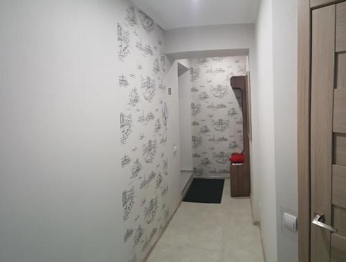 un pasillo con paredes blancas con dibujos en la pared en LOFT studio Apartment on Teslenkа street en Krivói Rog