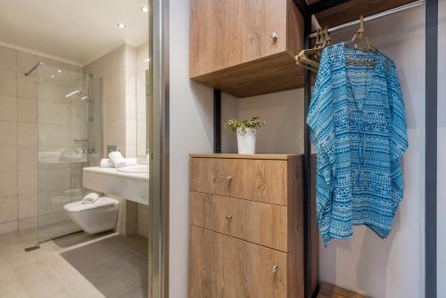 La salle de bains est pourvue d'une serviette bleue suspendue à une armoire. dans l'établissement Phoenix Beach Hotel, à Planos