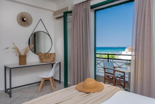 a bedroom with a bed and a view of the ocean at Phoenix Beach Hotel in Plános