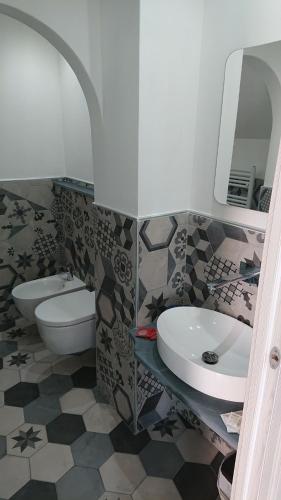 a bathroom with a sink and a toilet and a mirror at Affittacamere Rosa Dei Venti in Levanto
