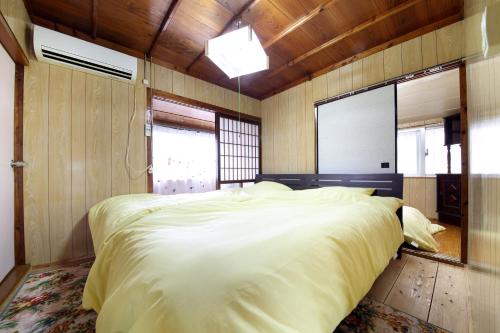 a bedroom with a large white bed in a room at Kume Azuma Villa in Kumejima