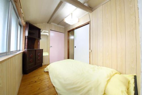a bedroom with a large white bed and a window at Kume Azuma Villa in Kumejima