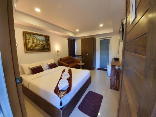 ein Hotelzimmer mit einem großen Bett und einem Sofa in der Unterkunft Chiang Mai Heritage House in Chiang Mai