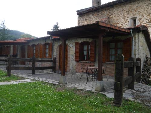 a building with a table and chairs in front of it at Hotel Rural Isasi in Gordexola