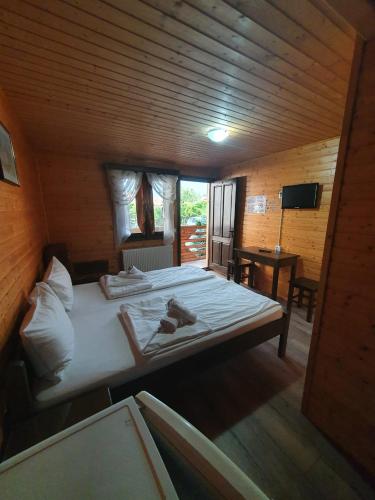 a bedroom with a large bed in a wooden room at Daiana Residence Cabane in Turda