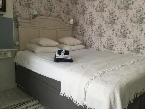 a bed with a white comforter and a bag on it at B&B-Fine Fleur in Zottegem