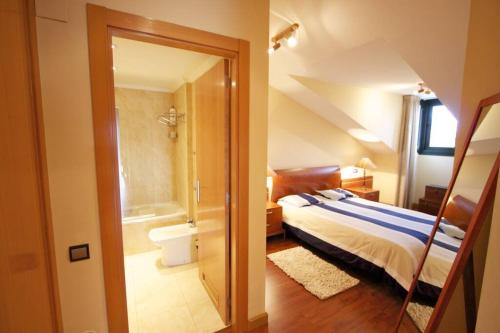 a bedroom with a bed and a bathroom with a shower at Atico centro Oviedo 3hab+garaje+terraza+wifi in Oviedo