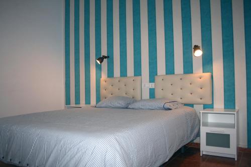 1 dormitorio con cama y pared a rayas en Bungalows Villas Blancas, en Puerto del Carmen