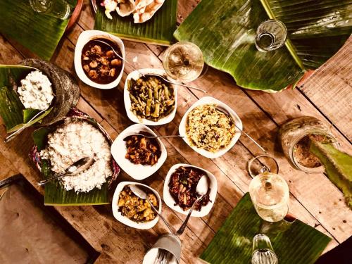 a table topped with bowls of food on top of leaves at Memo's Beach in Nilaveli