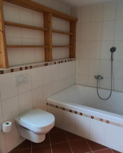a bathroom with a toilet and a bath tub at Alpchalet Tirol in Berwang