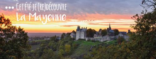 a castle on a hill with a sunset in the background at Au Pigeon Blanc in Andouillé