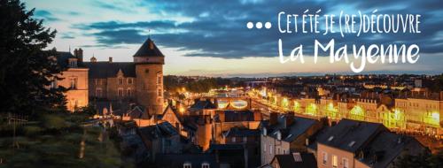 a view of a city at night with a castle tower at Au Pigeon Blanc in Andouillé