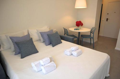 a bedroom with a white bed with pillows and a table at La finestra "sul Lago" in Predore