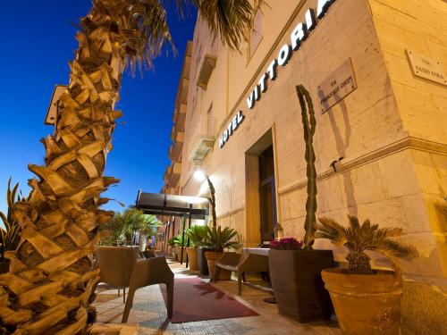 un restaurante con mesas y sillas fuera de un edificio en Hotel Vittoria, en Trapani