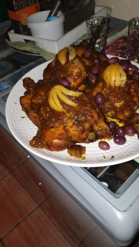 a plate of food with meat and fruit on a counter at Hôtel restaurant le delta in Saintes-Maries-de-la-Mer